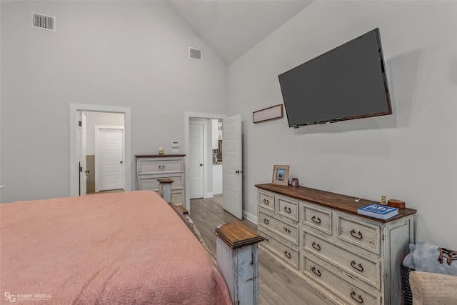 bedroom with high vaulted ceiling and light hardwood / wood-style floors