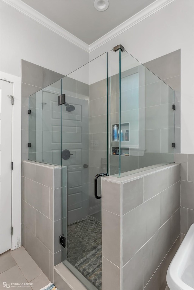 bathroom with crown molding, tile patterned flooring, and a shower with shower door