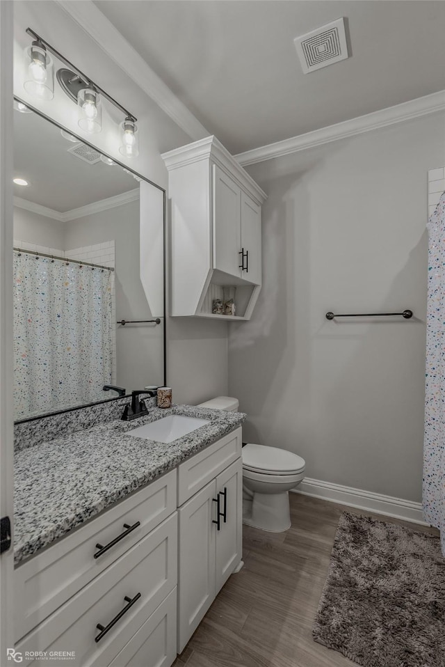 bathroom with toilet, vanity, wood-type flooring, and ornamental molding