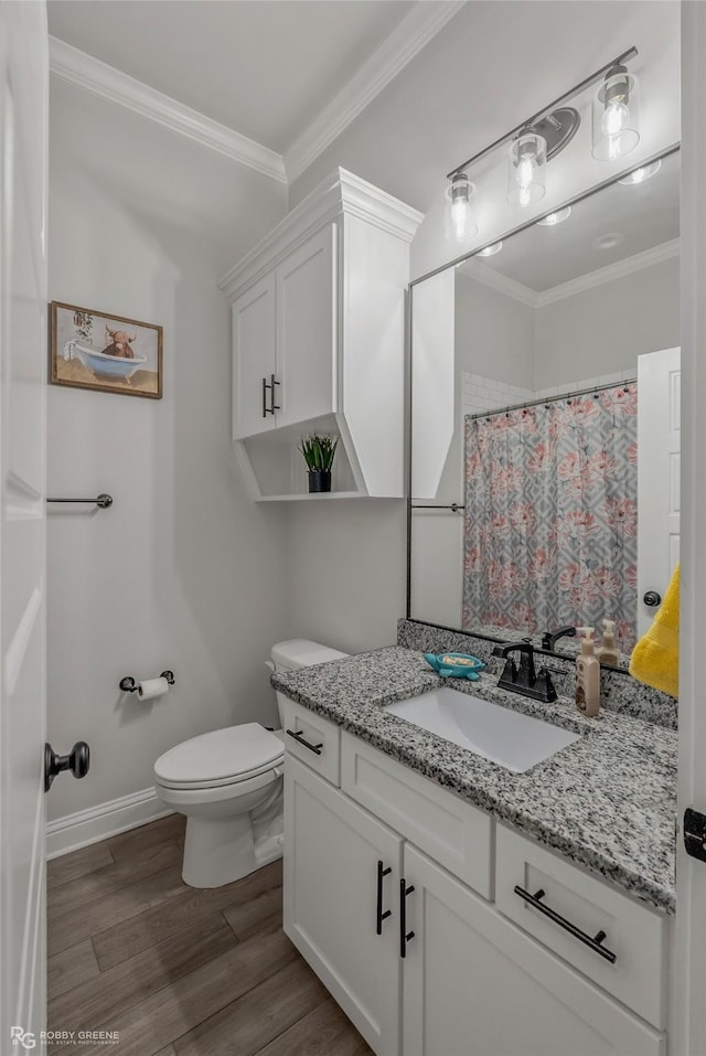 bathroom with a shower with shower curtain, ornamental molding, vanity, hardwood / wood-style flooring, and toilet