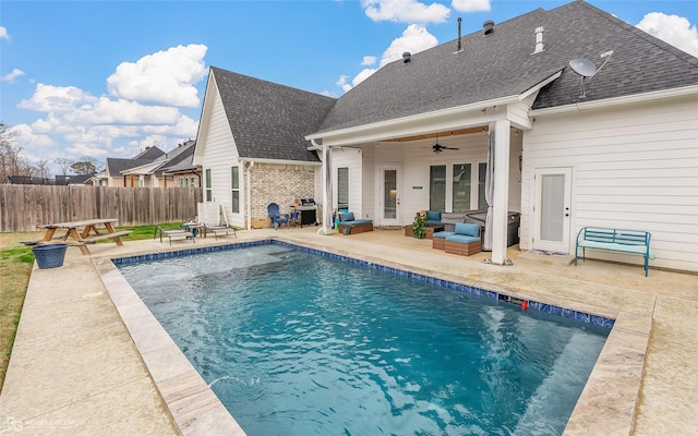 view of swimming pool with grilling area, ceiling fan, and a patio area