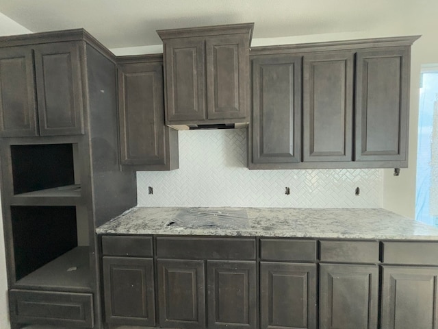 kitchen featuring light stone counters and tasteful backsplash