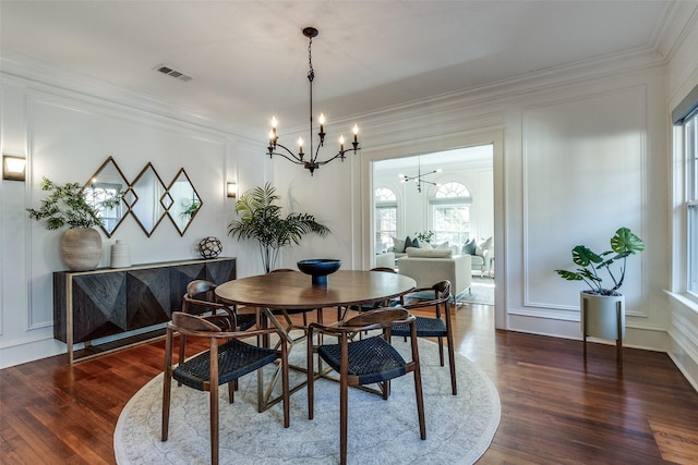 dining room featuring a notable chandelier, dark hardwood / wood-style floors, and ornamental molding