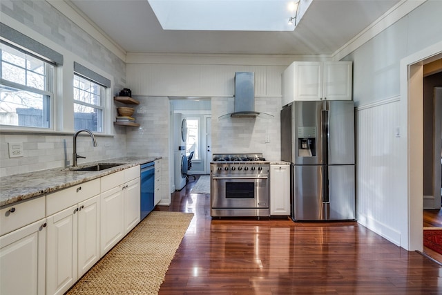 kitchen featuring wall chimney exhaust hood, decorative backsplash, light stone counters, white cabinetry, and stainless steel appliances