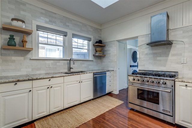 kitchen featuring light stone countertops, appliances with stainless steel finishes, extractor fan, sink, and stacked washer and dryer