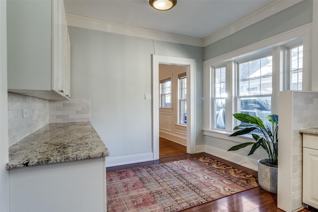 doorway to outside with crown molding, dark hardwood / wood-style flooring, and a healthy amount of sunlight