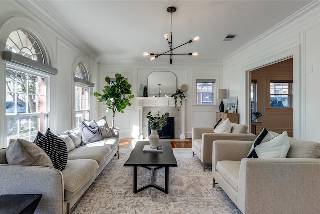 living room featuring light hardwood / wood-style flooring, crown molding, and a chandelier