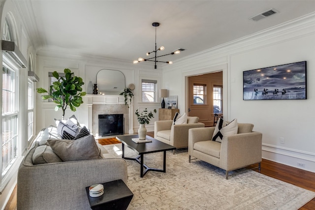 living room featuring light hardwood / wood-style floors, ornamental molding, and a chandelier