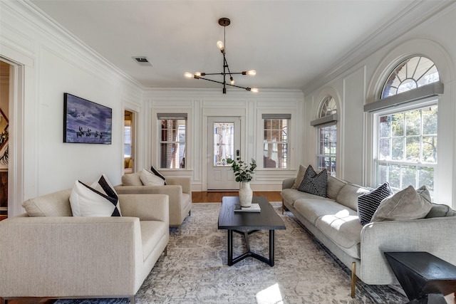 living room featuring light hardwood / wood-style floors, crown molding, and an inviting chandelier