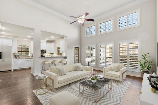 living room with hardwood / wood-style floors, ceiling fan, ornamental molding, and a healthy amount of sunlight