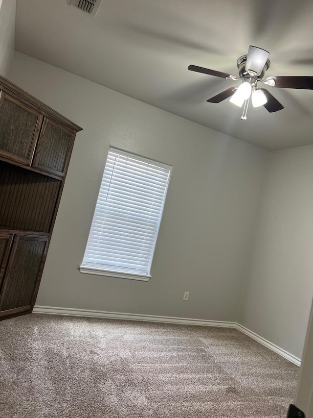 carpeted spare room with ceiling fan