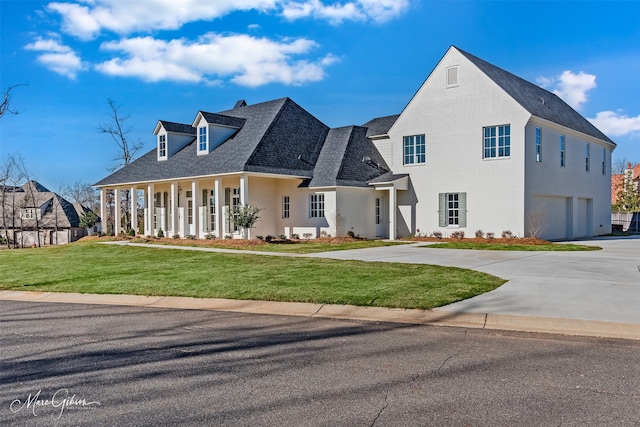 view of front of property with a garage, a front yard, and a porch