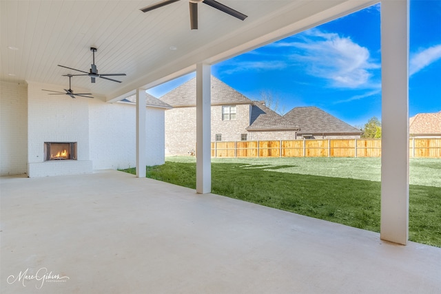 view of patio featuring an outdoor brick fireplace and ceiling fan