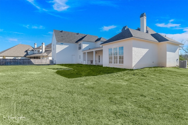 back of property featuring cooling unit and a lawn