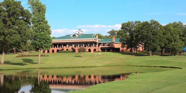 surrounding community featuring a lawn and a water view