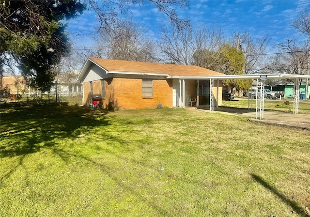 back of house with a lawn and a carport