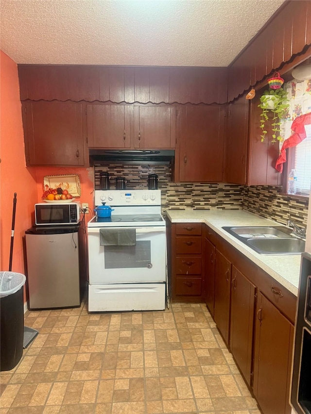 kitchen with tasteful backsplash, a textured ceiling, white electric range oven, stainless steel refrigerator, and sink