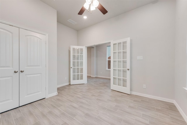 spare room with a ceiling fan, french doors, visible vents, and light wood-style flooring