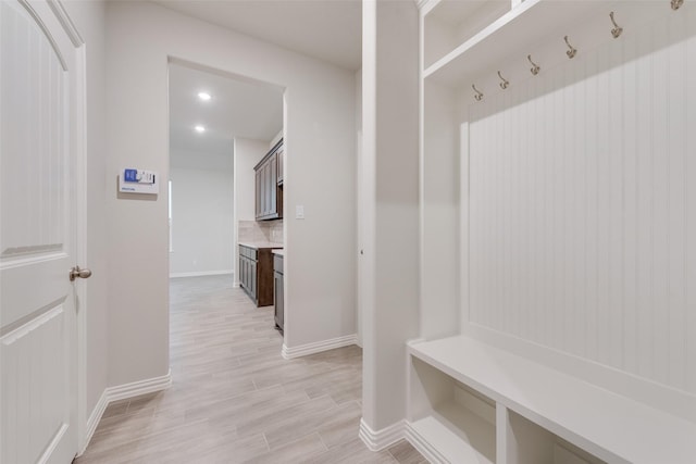 mudroom with recessed lighting, light wood-type flooring, and baseboards