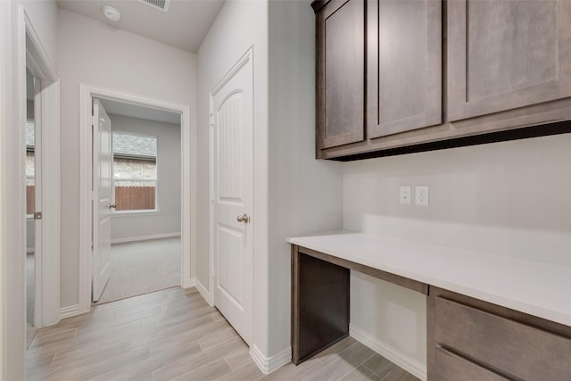 hall with light wood finished floors and baseboards