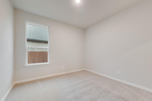 carpeted spare room featuring baseboards