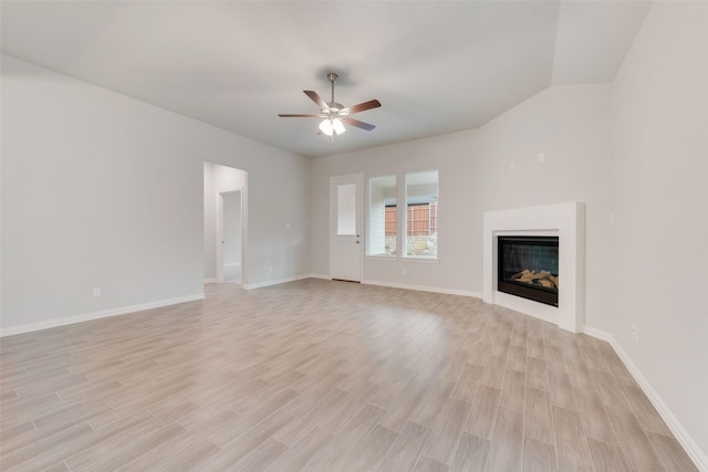 unfurnished living room with baseboards, a glass covered fireplace, a ceiling fan, and light wood-style floors