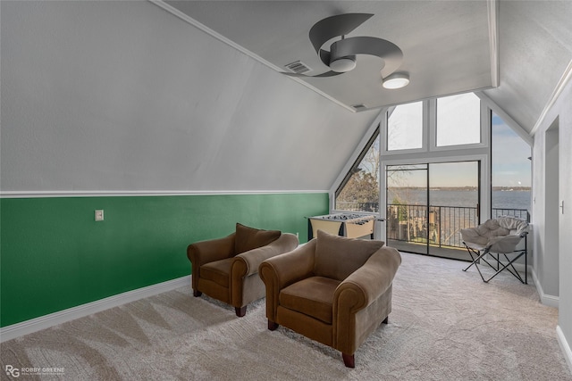 living area with light colored carpet, vaulted ceiling, ceiling fan, and a water view