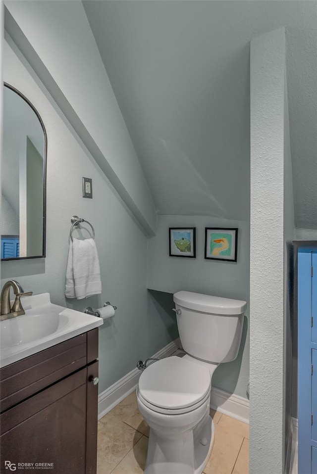 bathroom with toilet, vanity, and tile patterned floors