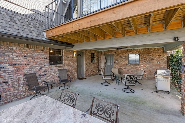 view of patio featuring grilling area, ceiling fan, and a balcony