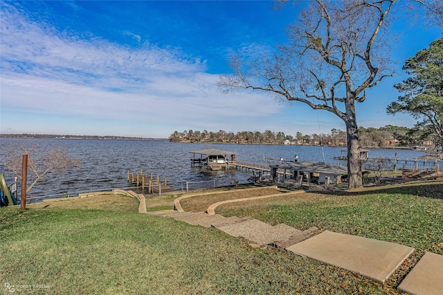 dock area with a lawn and a water view