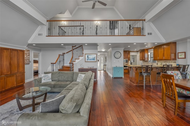 living room with ornamental molding and high vaulted ceiling