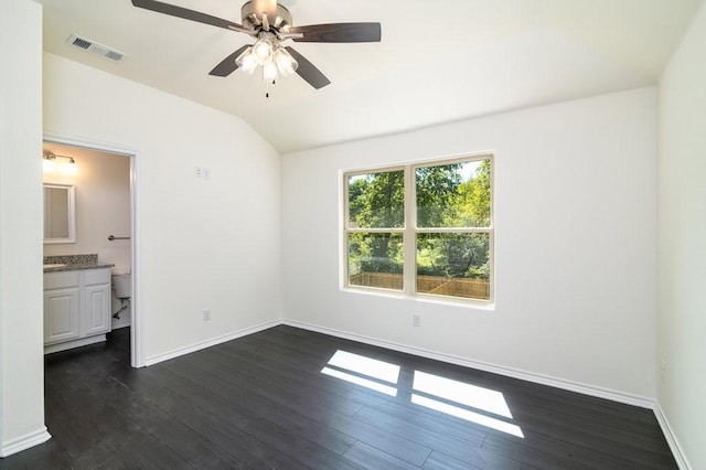 unfurnished bedroom featuring vaulted ceiling, ceiling fan, dark hardwood / wood-style flooring, and ensuite bath