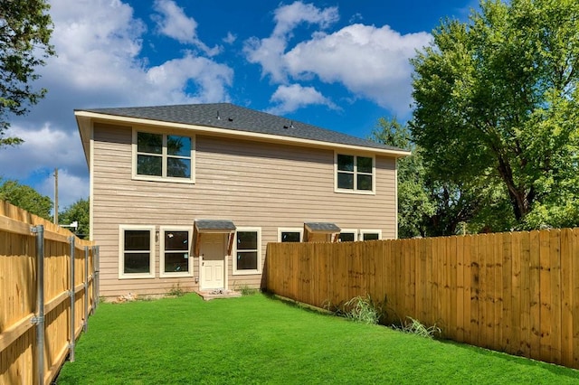 rear view of house featuring a lawn