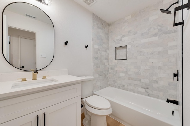 full bathroom with vanity, tiled shower / bath combo, and toilet