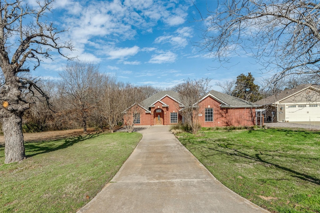 ranch-style home with a garage and a front lawn