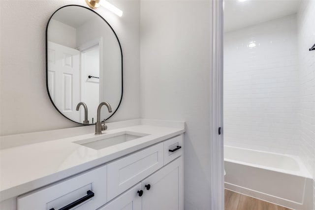 bathroom featuring hardwood / wood-style floors, vanity, and  shower combination