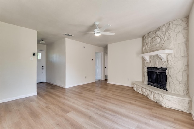 unfurnished living room with a fireplace, light hardwood / wood-style floors, and ceiling fan