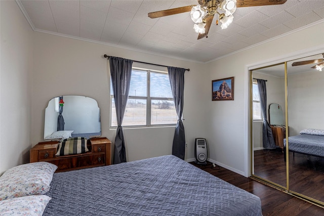 bedroom featuring crown molding, ceiling fan, dark hardwood / wood-style floors, and a closet