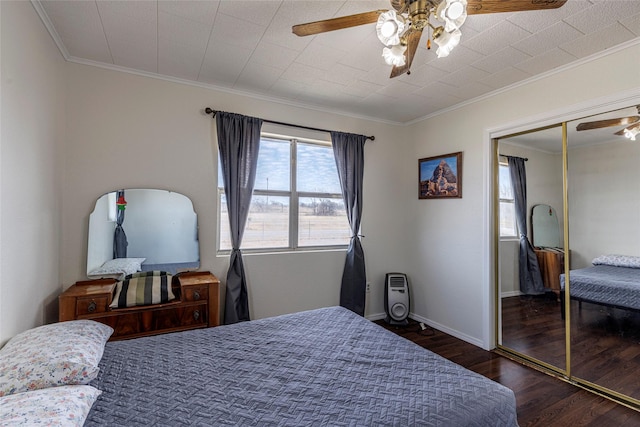 bedroom with crown molding, wood finished floors, ceiling fan, and a closet