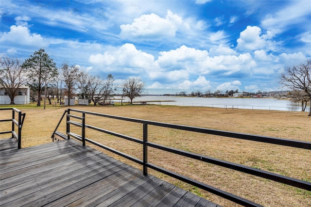 wooden deck with a yard and a water view