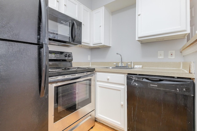 kitchen featuring sink, white cabinetry, and black appliances