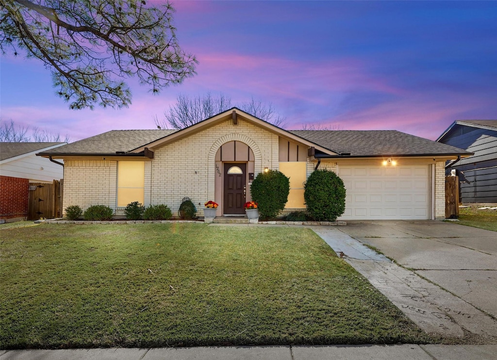 single story home with a yard and a garage