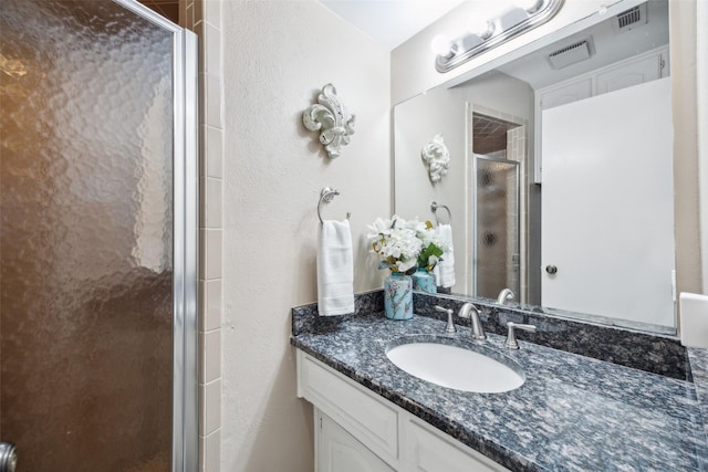 bathroom featuring vanity and an enclosed shower