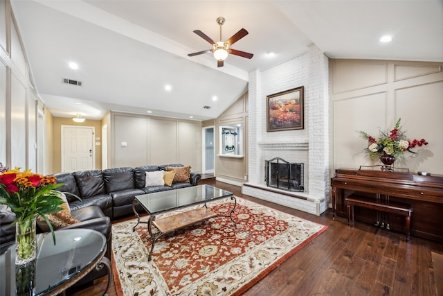 living room with dark hardwood / wood-style floors, ceiling fan, a fireplace, and vaulted ceiling