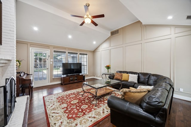 living room with ceiling fan, lofted ceiling, a fireplace, and dark hardwood / wood-style flooring