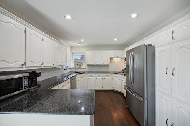 kitchen featuring stainless steel appliances, tasteful backsplash, sink, and white cabinets