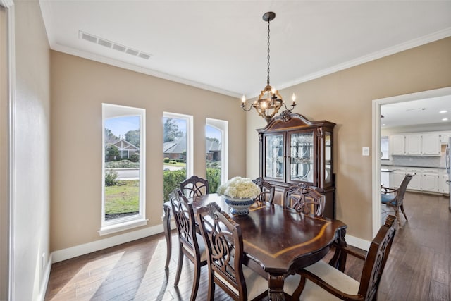 dining space featuring an inviting chandelier, dark wood-type flooring, and ornamental molding