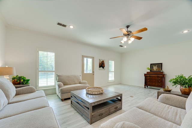 living room featuring ceiling fan, ornamental molding, and light hardwood / wood-style flooring