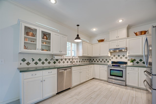 kitchen with sink, decorative light fixtures, ornamental molding, and stainless steel appliances