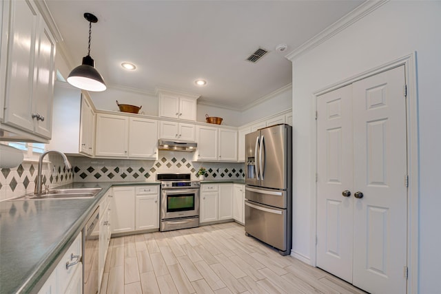 kitchen with white cabinetry, sink, tasteful backsplash, pendant lighting, and appliances with stainless steel finishes